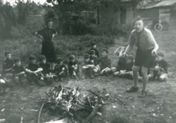 Tully and Gordon Slaughter around a Cub camp fire. This shows the rough ground we once had. The Flint Shed is just visible in the background, by the bike.
